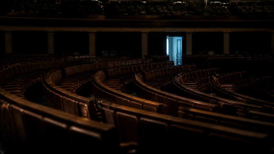 Salón legislativo vacío en penumbra con una puerta abierta al fondo, en referencia a la propuesta de escapar de la política en el pensamiento de Peter Thiel.