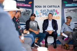 Mesa de atención municipal instalada en una comunidad rural con habitantes entregando solicitudes, sin rostros identificables