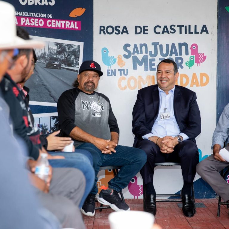 Mesa de atención municipal instalada en una comunidad rural con habitantes entregando solicitudes, sin rostros identificables